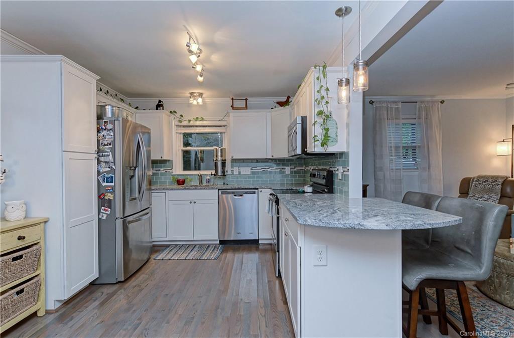 7407 Watercrest Road Charlotte, NC 28210 - Photo 10 of 42 a kitchen with stainless steel appliances granite countertop a refrigerator a sink dishwasher a stove and white countertops with wooden floor