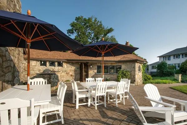 a view of a patio with a table and chairs under an umbrella
