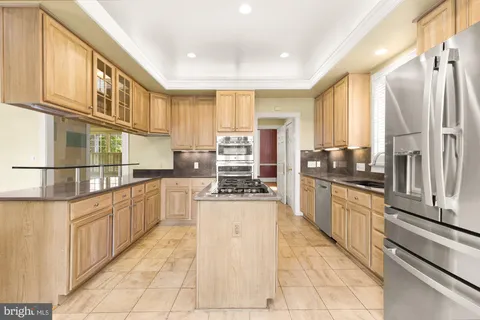 a large kitchen with stainless steel appliances granite countertop a stove and cabinets