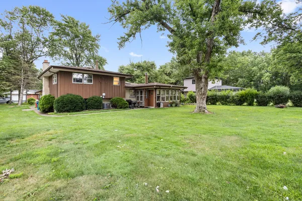 a view of a house with backyard and a tree