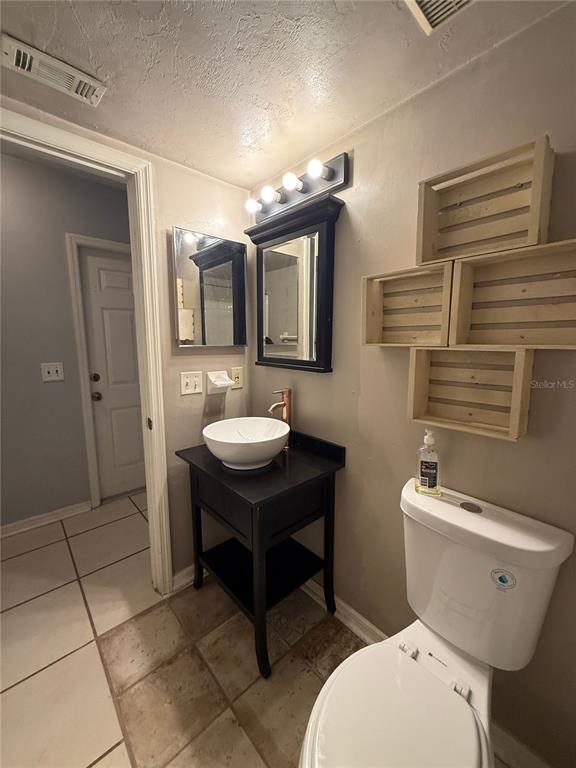 7200 Southwest 8th Avenue, Unit T128 Gainesville, FL 32607 - Photo 17 of 38 a bathroom with a sink a toilet and mirror