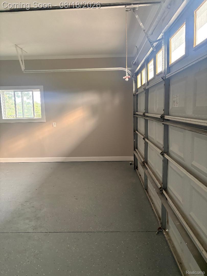 32563 Sutton Road New Baltimore, MI 48047 - Photo 41 of 43 Epoxy-coated concrete flooring, garage door with upper window inserts, interior window, and painted walls