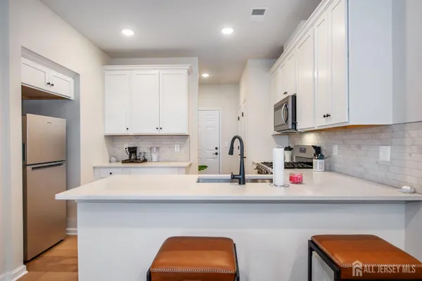 a kitchen with stainless steel appliances granite countertop a sink a refrigerator and a stove