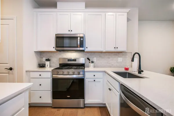 a kitchen with white cabinets and white appliances