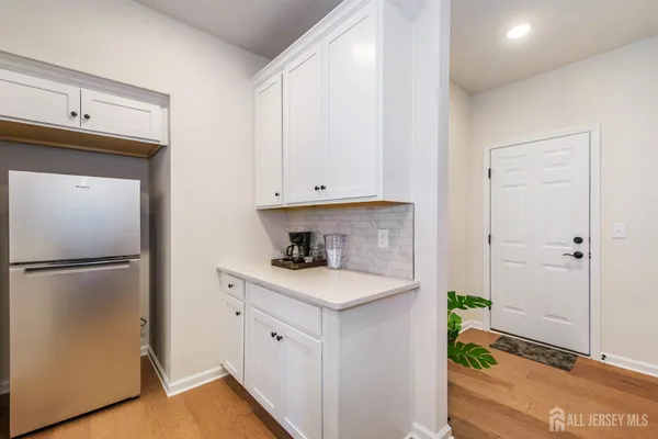 a kitchen with a refrigerator a stove and white cabinets