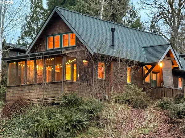 a view of a brick house with large windows and a yard