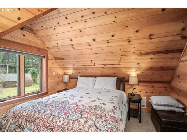 a bedroom with a bed and a large window