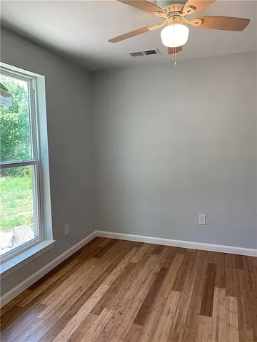 a room with a wooden floor and window