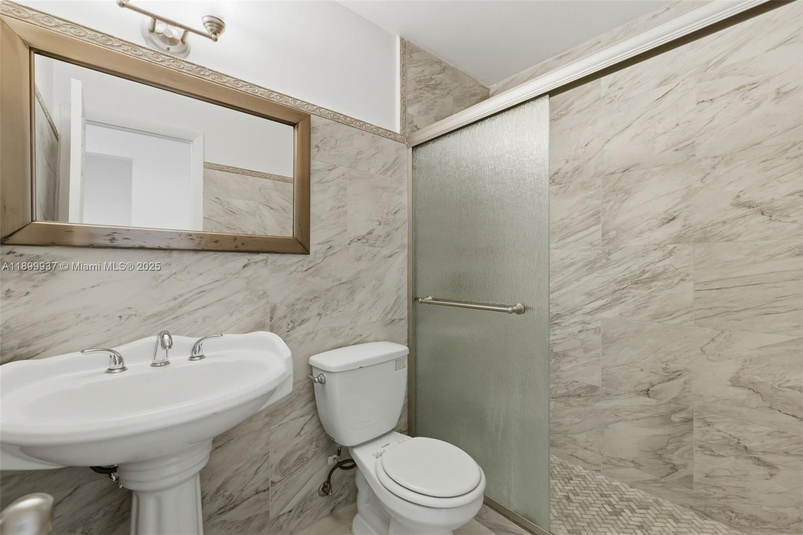 624 Northwest 11th Street, Unit 624 Miami, FL 33136 - Photo 24 of 30 a bathroom with a sink mirror and toilet