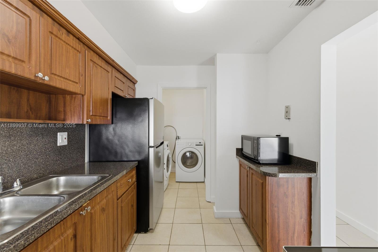 624 Northwest 11th Street, Unit 624 Miami, FL 33136 - Photo 3 of 30 a kitchen with stainless steel appliances granite countertop a sink and a refrigerator