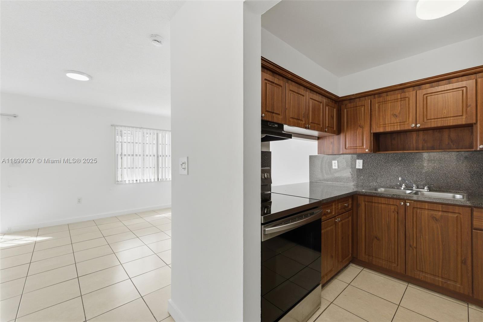 624 Northwest 11th Street, Unit 624 Miami, FL 33136 - Photo 5 of 30 a kitchen with granite countertop a stove a sink and a refrigerator