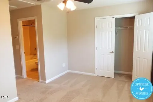 an empty room with wooden floor and bathroom