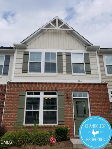 a view of a house with a yard and potted plants