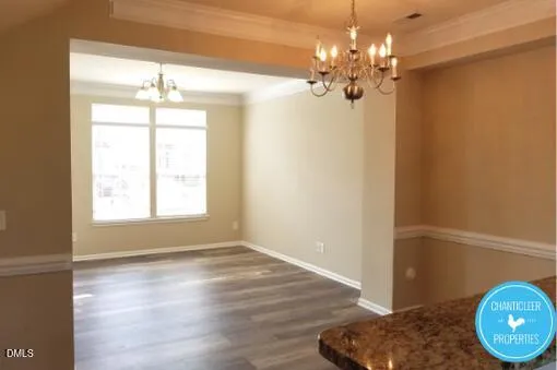 a view of a room with wooden floor and chandelier