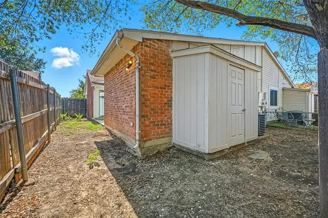 a view of a backyard with table and chairs and wooden fence