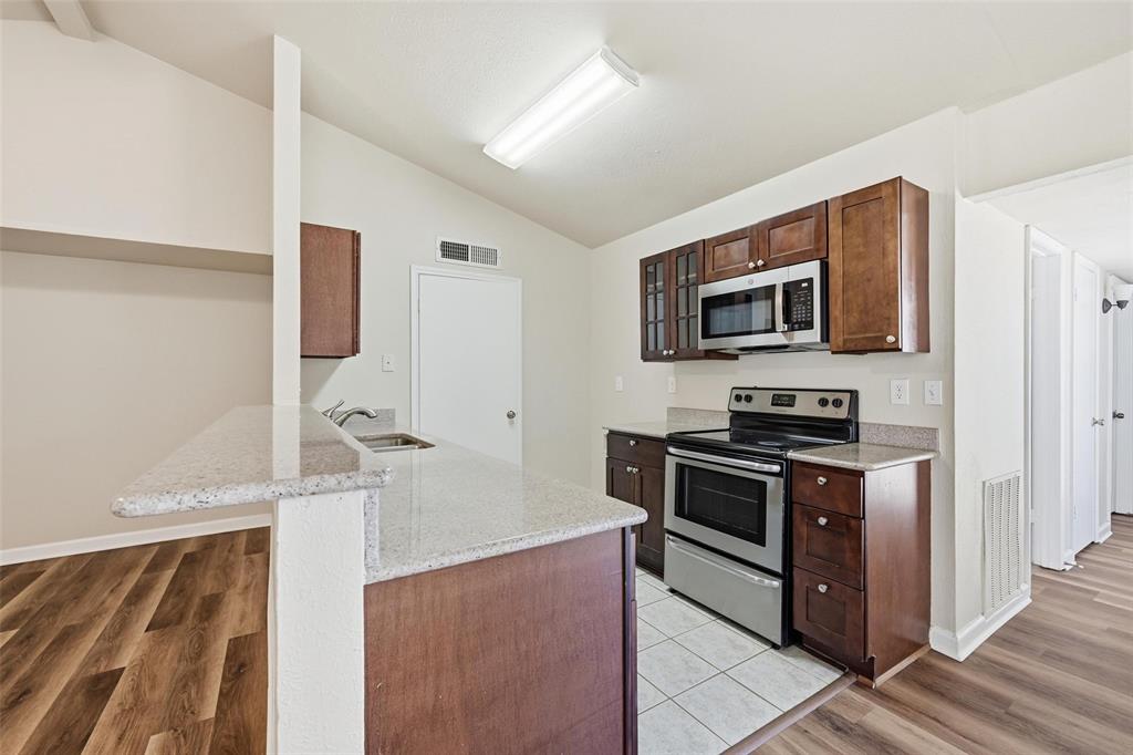4526 Carr Street The Colony, TX 75056 - Photo 3 of 19 a kitchen with stainless steel appliances a stove microwave and refrigerator