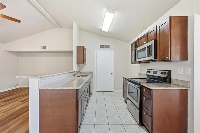 a kitchen with stainless steel appliances a stove microwave and refrigerator