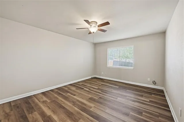 a view of a room with wooden floor and a ceiling fan