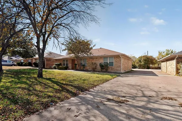a front view of a house with a yard and trees