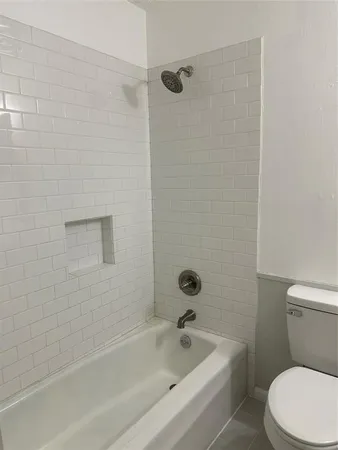 a white bath tub sitting next to a toilet
