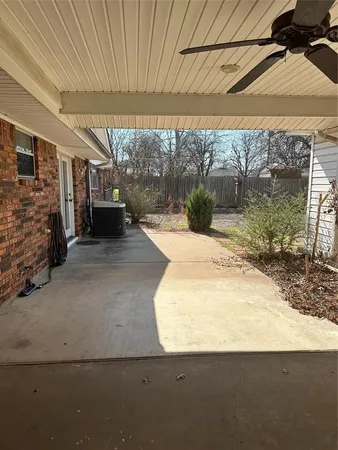 a backyard of a house with barbeque oven table and chairs under an umbrella