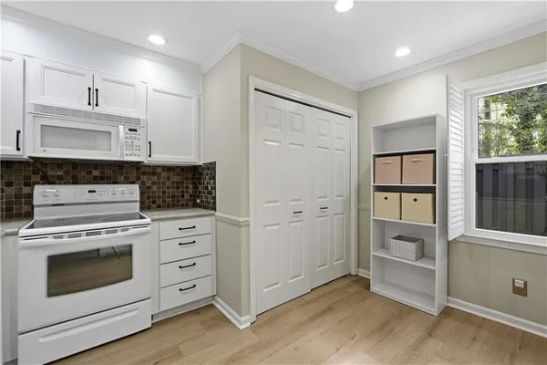 a kitchen with white cabinets and white appliances