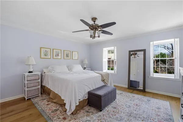 a bedroom with a bed dresser and wooden floor