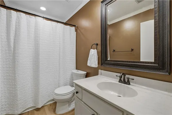 a bathroom with a sink vanity mirror and toilet