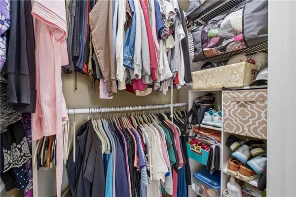 a view of walk in closet with clothes