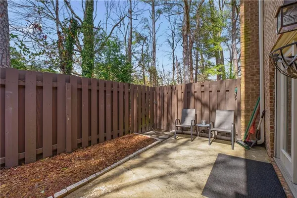 a view of backyard with wooden fence and large trees