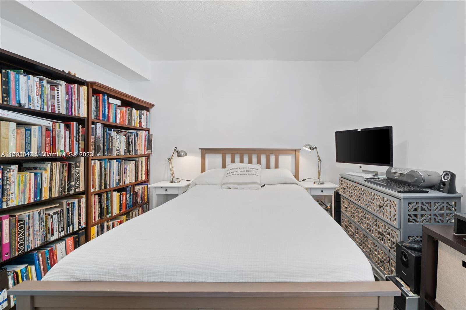 555 Northeast 70th Street Miami, FL 33138 - Photo 13 of 19 a bedroom with a bed and a book shelf