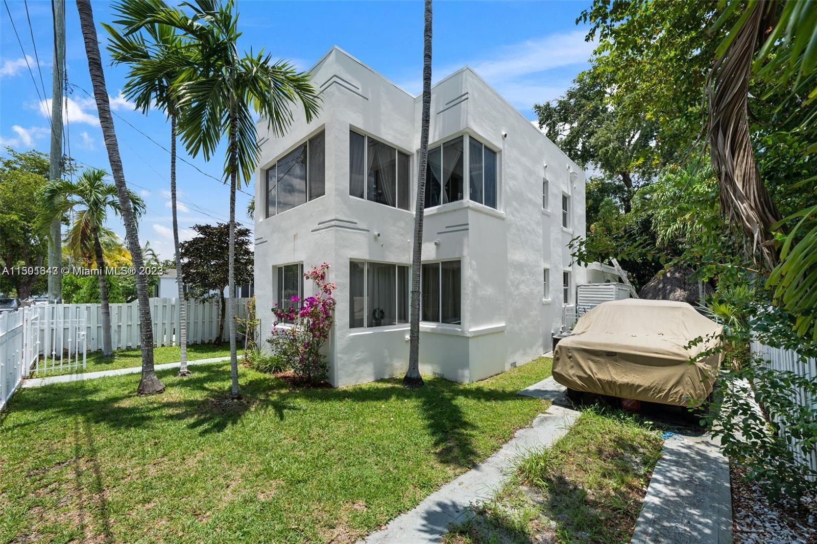 555 Northeast 70th Street Miami, FL 33138 - Photo 17 of 19 a view of a white house with a big yard and potted plants