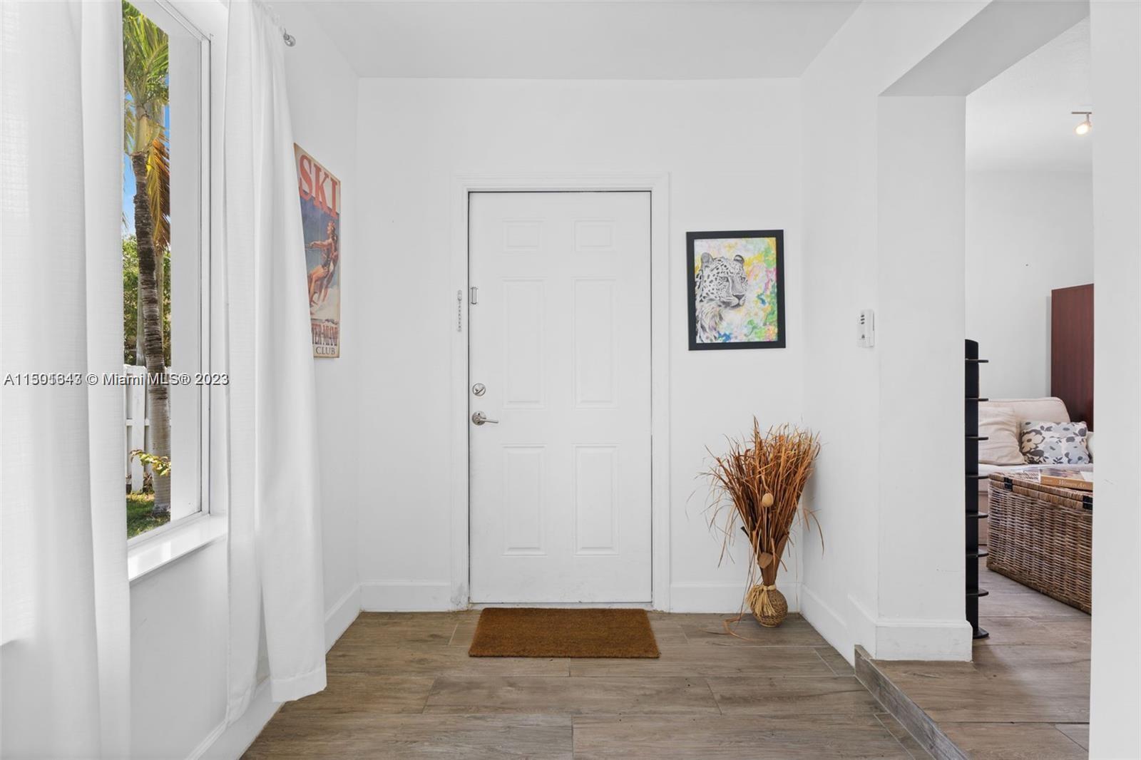 555 Northeast 70th Street Miami, FL 33138 - Photo 4 of 19 a view of a hallway with wooden floor and a livingroom