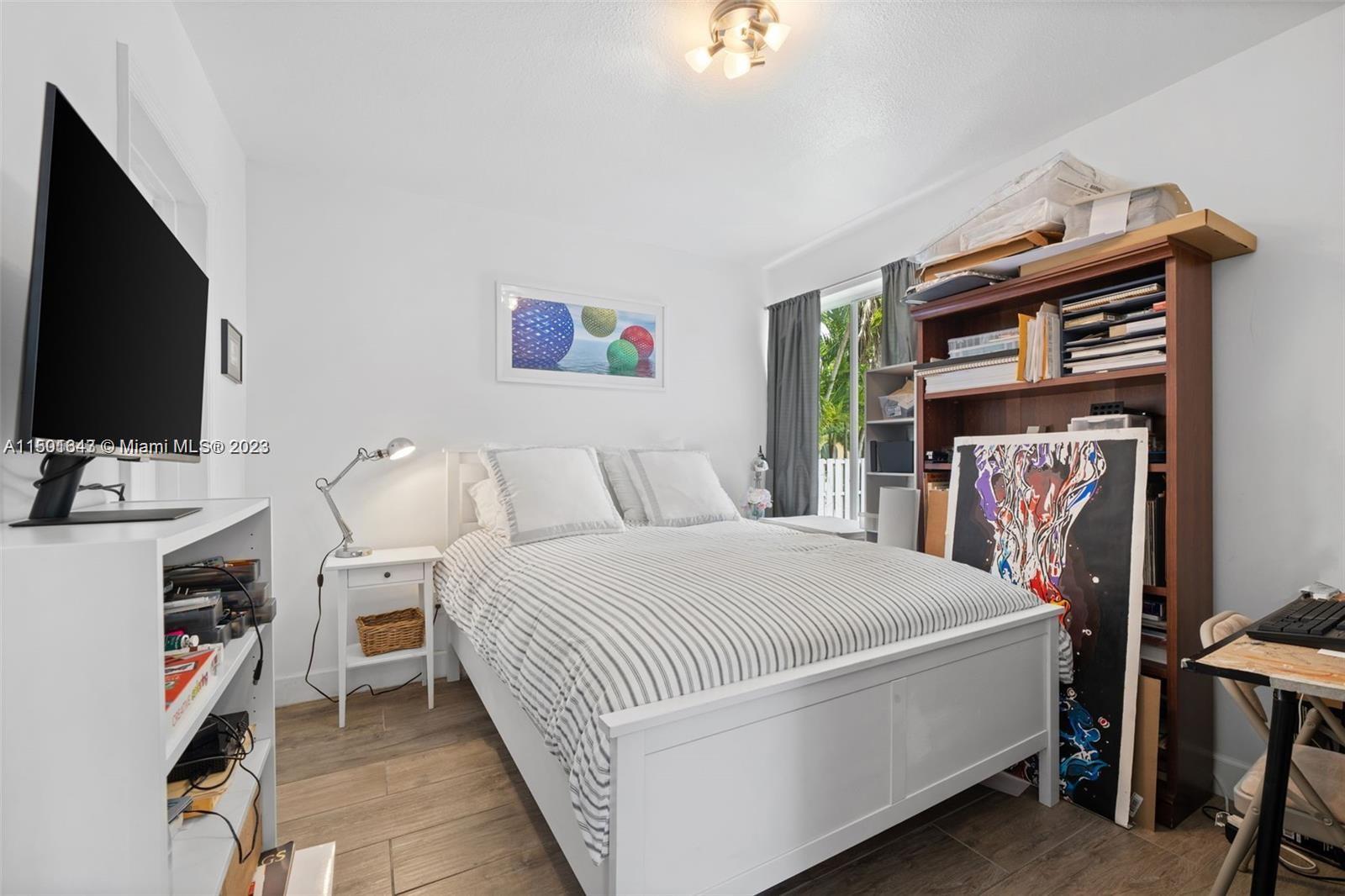 555 Northeast 70th Street Miami, FL 33138 - Photo 7 of 19 a bedroom with a bed and a flat screen tv