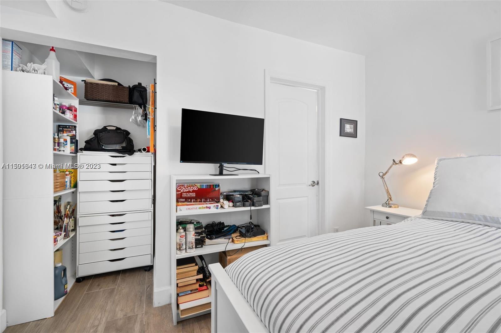 555 Northeast 70th Street Miami, FL 33138 - Photo 8 of 19 a bedroom with a bed and a flat tv screen