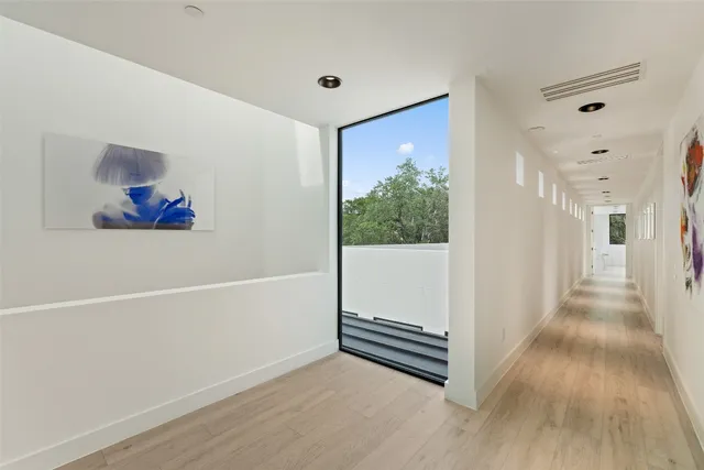 a view of a hallway with wooden floor and cabinet