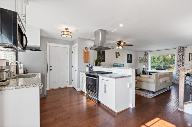 12152 Cinnamon Ridge Road Sandy, UT 84094 - Photo 12 of 51 Open-concept kitchen featuring hardwood flooring, white cabinetry, granite countertops, and stainless steel appliances
