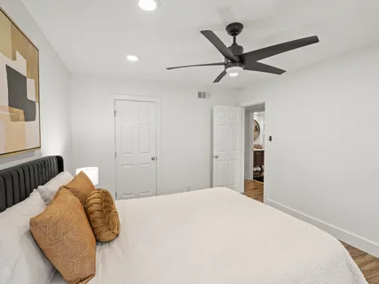 a bedroom with a bed and a ceiling fan