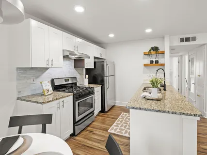 a kitchen with kitchen island a stove a sink and a refrigerator