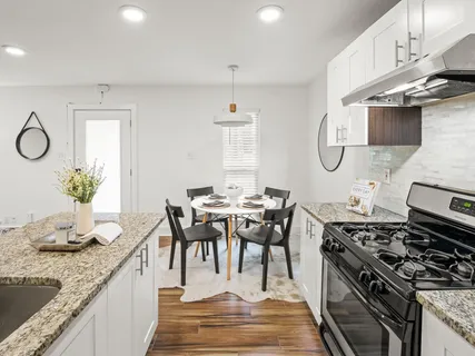 a kitchen with stainless steel appliances granite countertop a stove a sink and a refrigerator