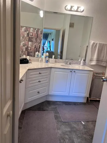 a bathroom with a granite countertop sink and a mirror