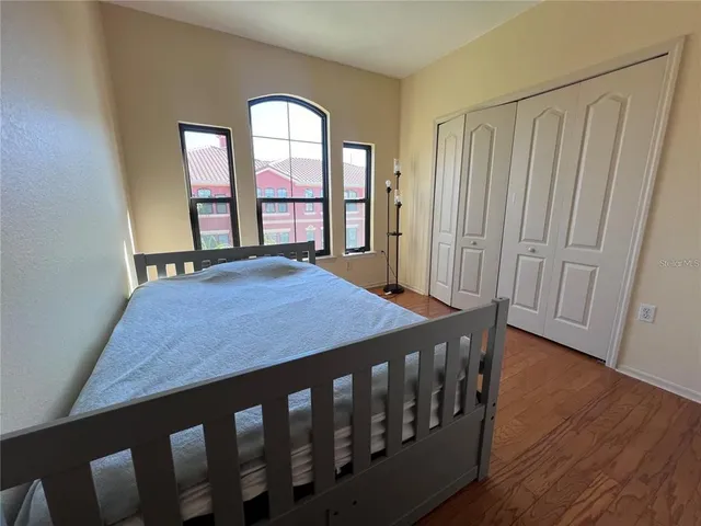 a bedroom with a bed window and wooden floor