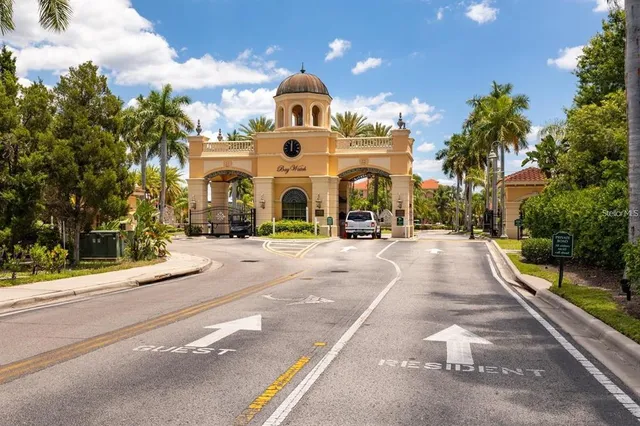 a view of a sign board with buildings in the background
