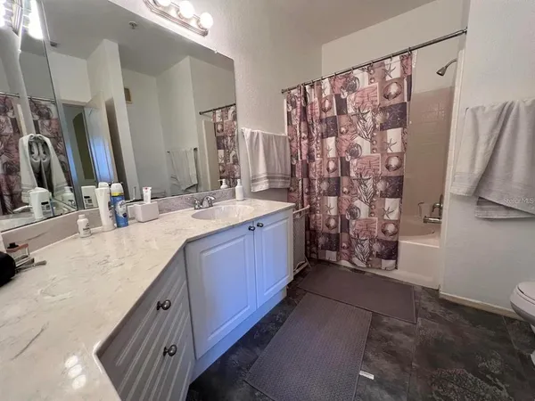 a spacious bathroom with double vanity and a mirror