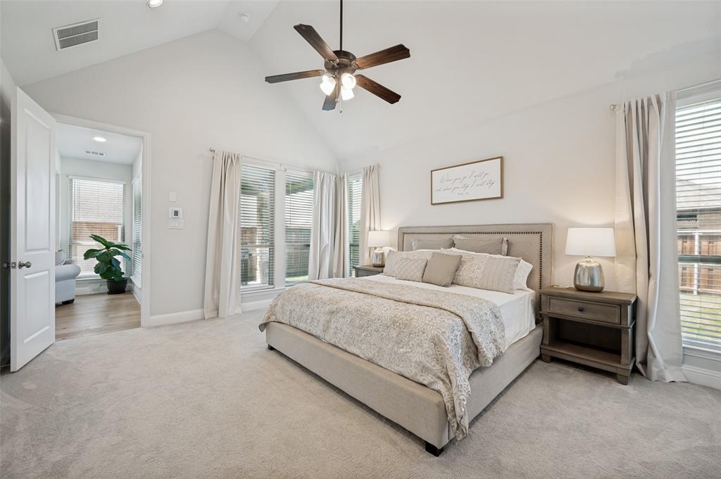 8440 Colburn The Colony, TX 75056 - Photo 12 of 34 Retreat to the spacious primary suite featuring vaulted ceilings, abundant natural light, and serene backyard views. With room for oversized furnishings and direct access to the luxurious ensuite bath, this private owner's retreat offers the perfect blend of comfort, space, and tranquility.