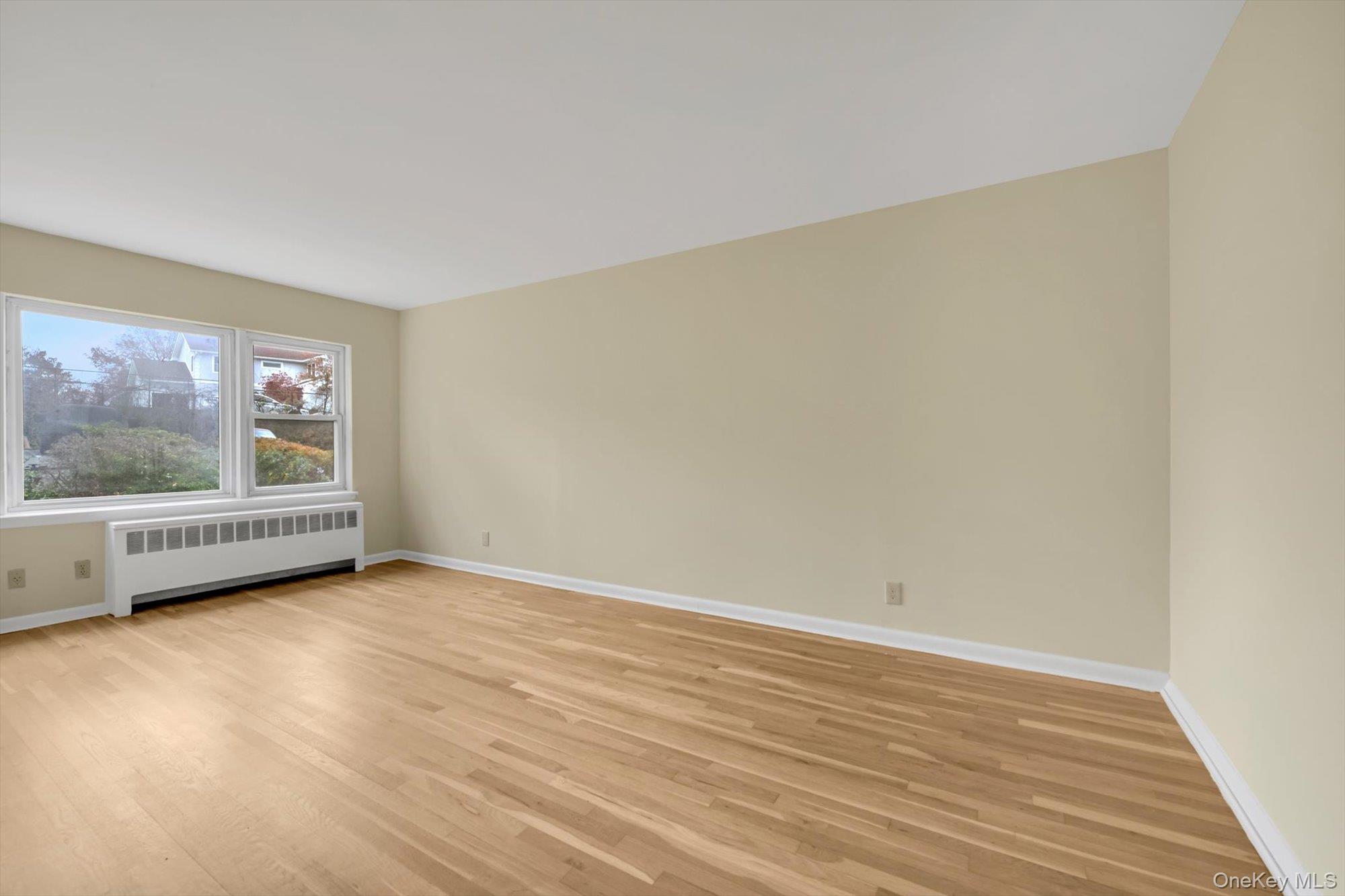 643 Pelham Road, Unit 6D New Rochelle, NY 10805 - Photo 4 of 12 a view of an empty room with wooden floor and a window