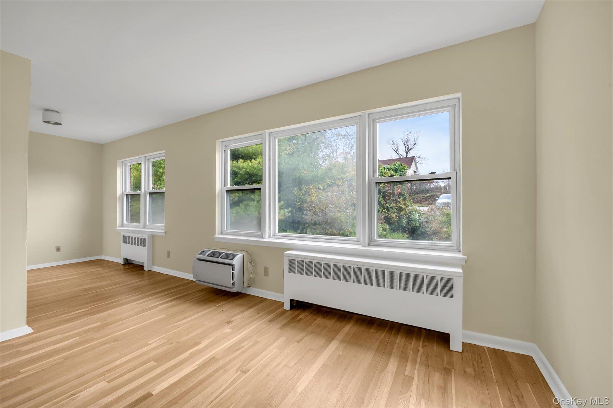 643 Pelham Road, Unit 6D New Rochelle, NY 10805 - Photo 5 of 12 a view of an empty room with wooden floor and a window