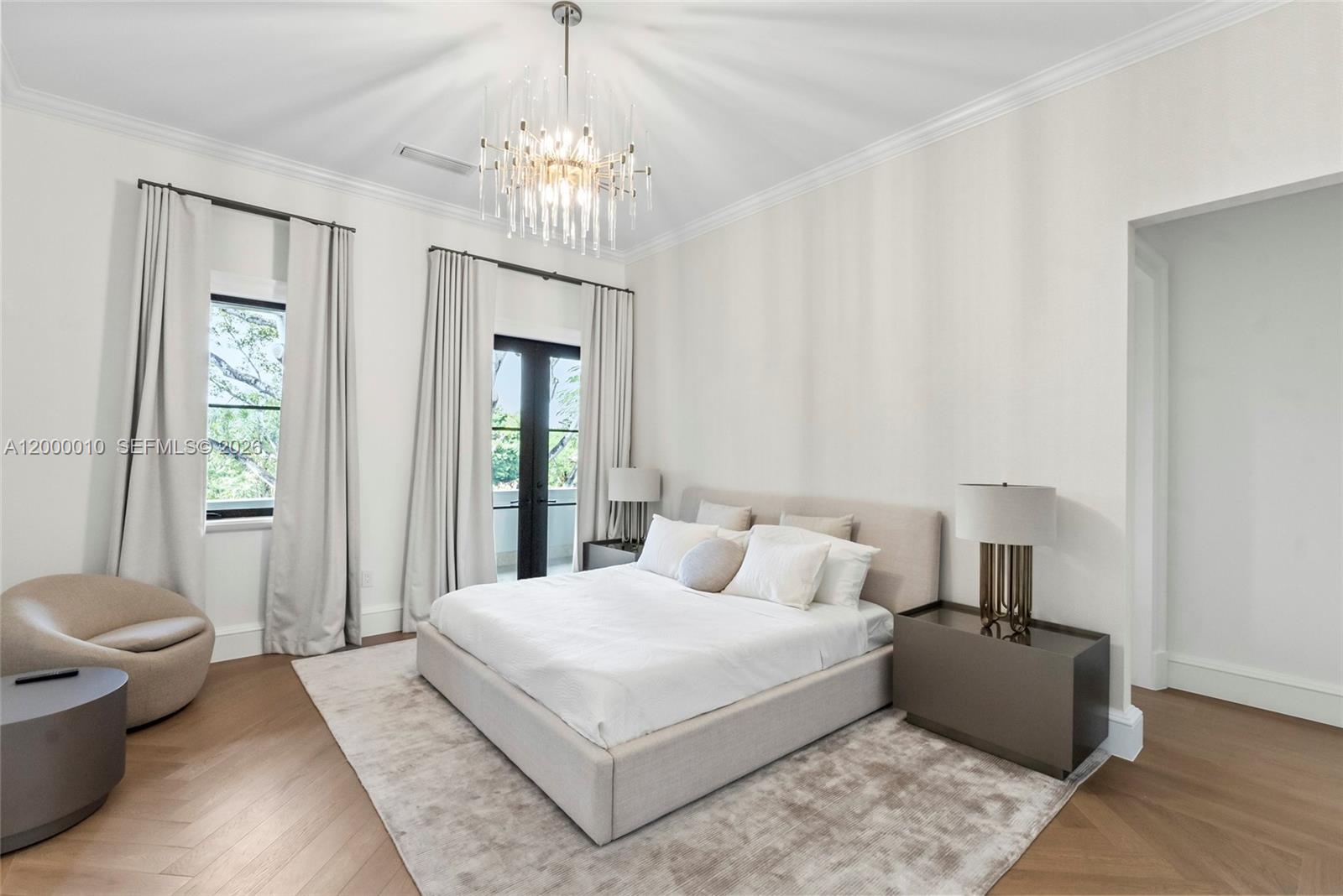 2617 Anderson Road Coral Gables, FL 33134 - Photo 38 of 49 a bedroom with a large bed and a chandelier