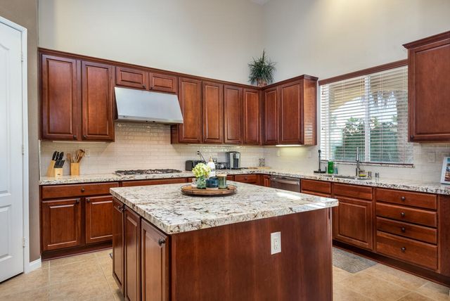 a kitchen with granite countertop wooden cabinets a sink and dishwasher