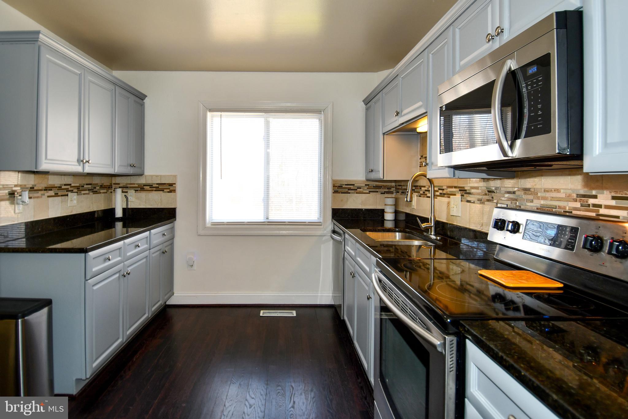 12604 Dulcinea Place Woodbridge, VA 22192 - Photo 23 of 63 a kitchen with stainless steel appliances a stove a sink and a microwave
